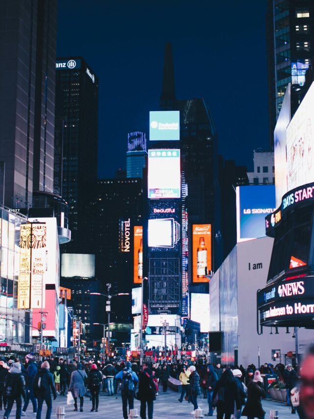 Bustling night scene in Times Square, New York City, illuminated with vibrant advertisements.